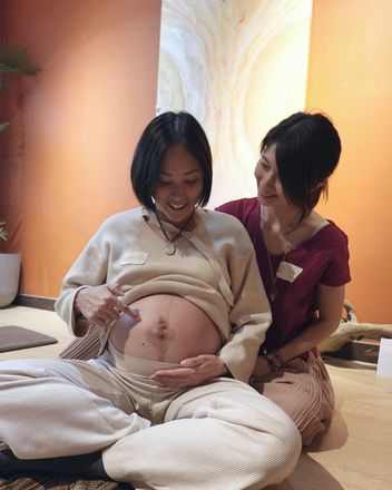 Milliya 陪著孕婦摸著肚子微笑